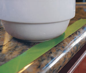 Bowl on edge of countertop marked with green painter's tape 