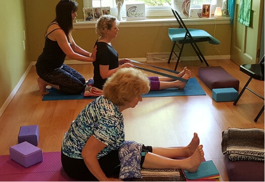 Janet Golownia (left, kneeling) teaches yoga and has found that the practice has opened up her life in unexpected ways. Photo courtesy of Janet Golownia