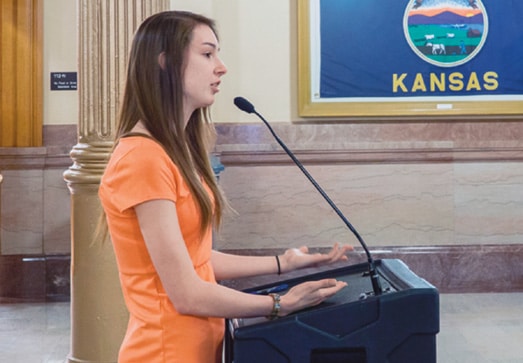 Marcillene Dover, then 22, speaks of living with MS without health insurance at the State Action Day in Kansas in 2014. The experience of speaking out was empowering, she says. Photo courtesy of Marcillene Dover