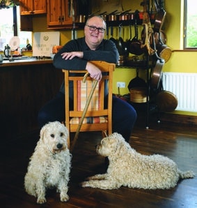Trevis Gleason in kitchen with his dogs