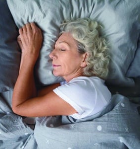 senior-aged woman sleeping in a bed
